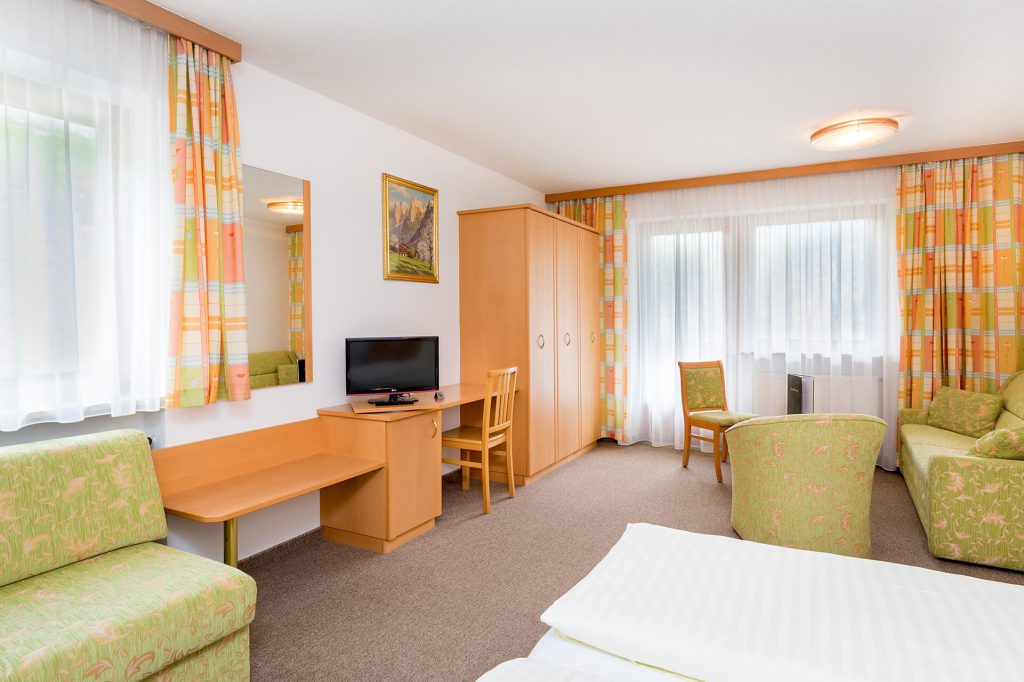 Bright room in Hotel Grissemann Flirsch with sofa, desk, mountain view, and feel-good ambiance