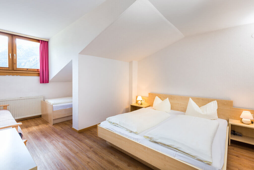 Bright double room in Hotel Grissemann Flirsch with mountain view, ideal for holidays in the Arlberg region