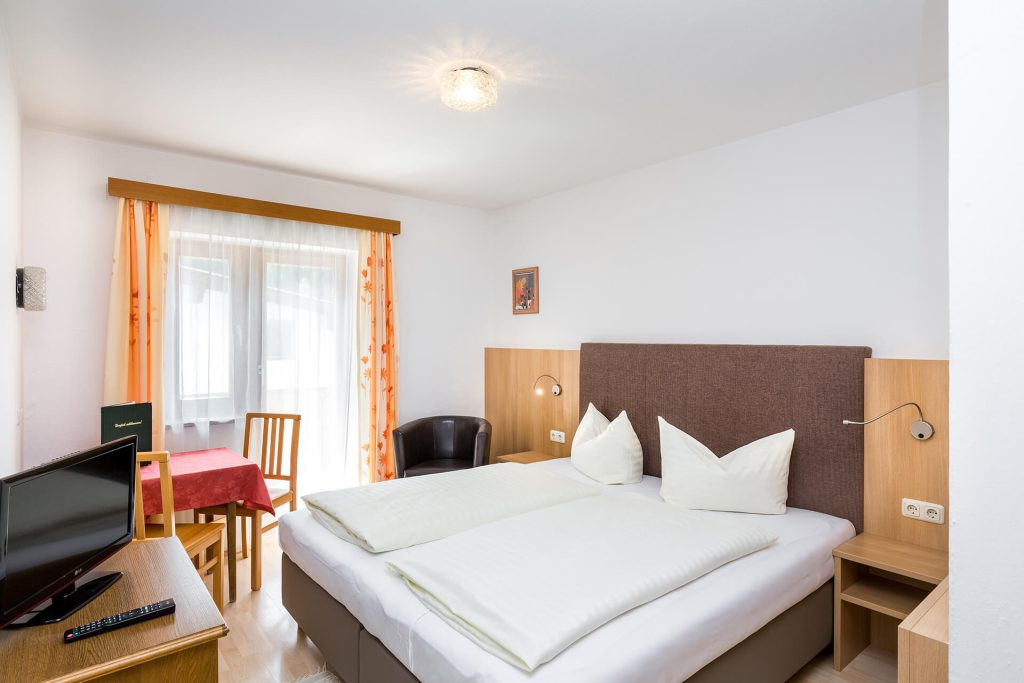 Bright double room in Hotel Grissemann Flirsch, cozy with TV, seating area and balcony