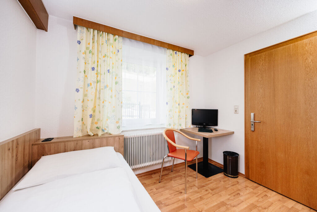 Bright single room with desk and TV in Hotel Grissemann Flirsch am Arlberg